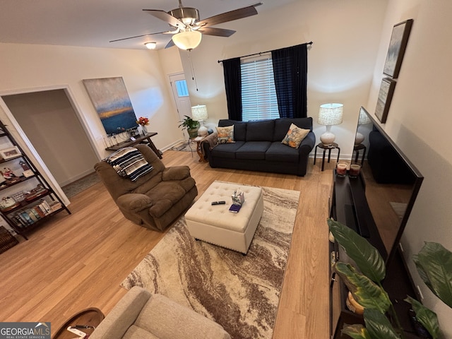 living room featuring ceiling fan, vaulted ceiling, and light hardwood / wood-style flooring