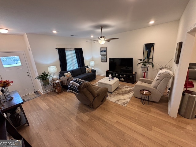 living room with light hardwood / wood-style floors and ceiling fan