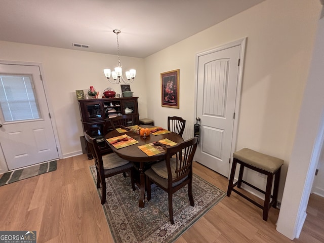 dining area with a chandelier and light hardwood / wood-style flooring