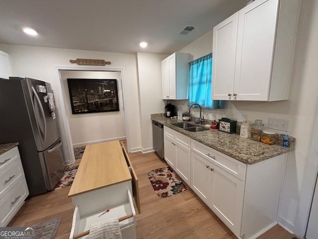 kitchen with sink, light hardwood / wood-style flooring, white cabinetry, butcher block counters, and stainless steel appliances