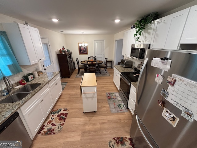 kitchen with white cabinets, light hardwood / wood-style floors, and stainless steel appliances