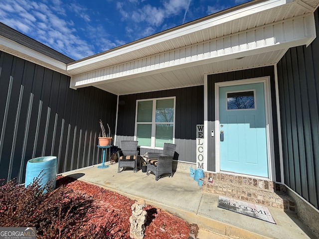 view of exterior entry featuring covered porch