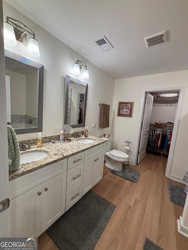 bathroom featuring hardwood / wood-style floors, vanity, and toilet