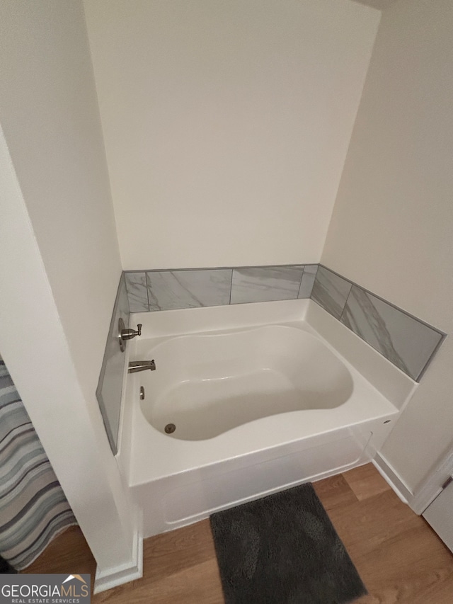 bathroom featuring wood-type flooring and a bathtub