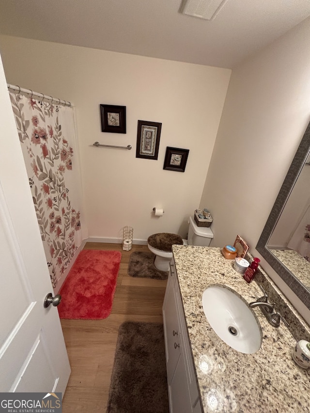 full bathroom with hardwood / wood-style flooring, vanity, toilet, and shower / bathtub combination with curtain