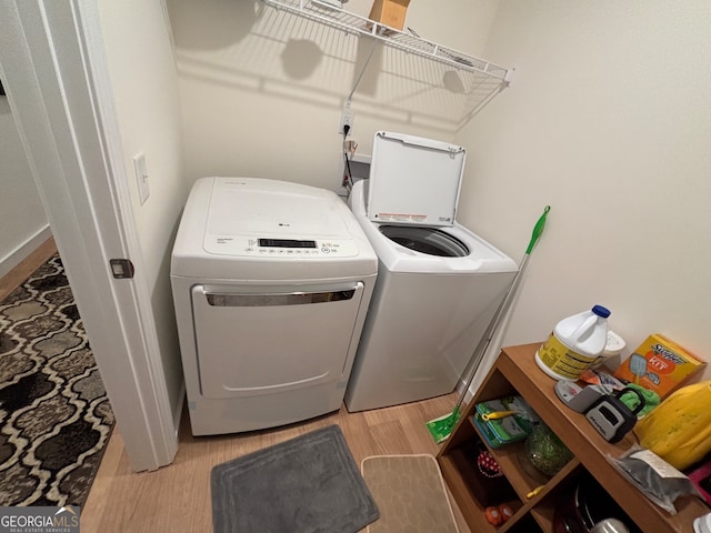 laundry area with washer and clothes dryer and light hardwood / wood-style flooring