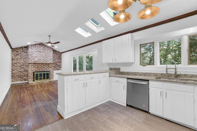 kitchen with stainless steel dishwasher, sink, white cabinets, kitchen peninsula, and lofted ceiling