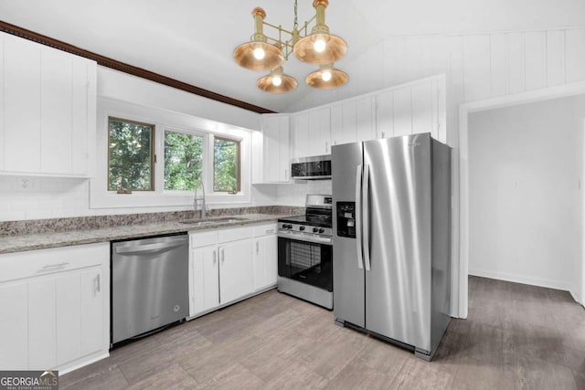 kitchen featuring sink, white cabinetry, hanging light fixtures, and appliances with stainless steel finishes