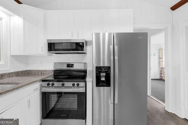 kitchen with light stone counters, white cabinets, and appliances with stainless steel finishes