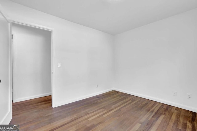 spare room featuring dark wood-type flooring