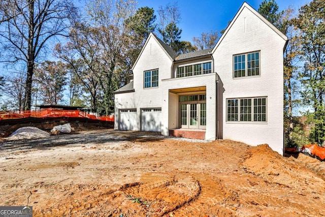 back of property featuring a garage and french doors