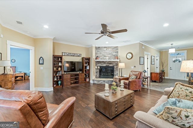 living room with ceiling fan, a stone fireplace, crown molding, and dark wood-type flooring