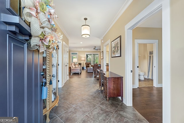 foyer entrance featuring ceiling fan, dark hardwood / wood-style flooring, and crown molding