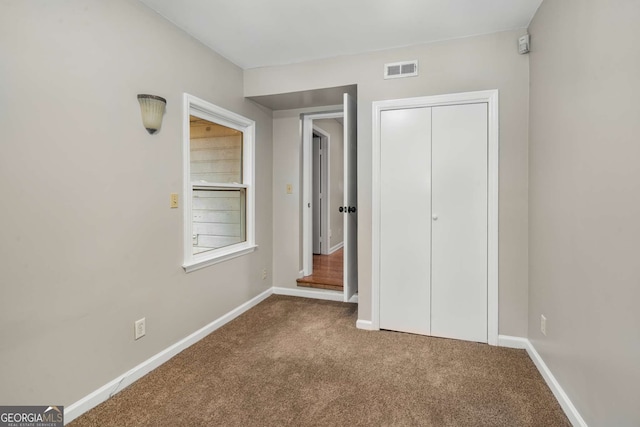 unfurnished bedroom featuring carpet flooring and a closet