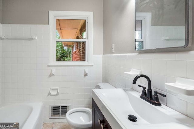 bathroom with plenty of natural light, a bath, toilet, and tile walls