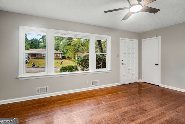 empty room featuring a textured ceiling, hardwood / wood-style flooring, and ceiling fan