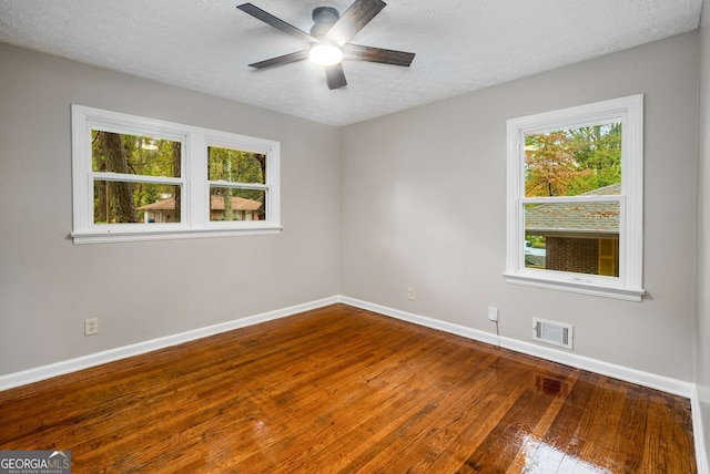 empty room featuring ceiling fan, a textured ceiling, and hardwood / wood-style flooring