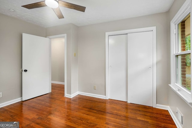 unfurnished bedroom with a textured ceiling, a closet, hardwood / wood-style flooring, and ceiling fan