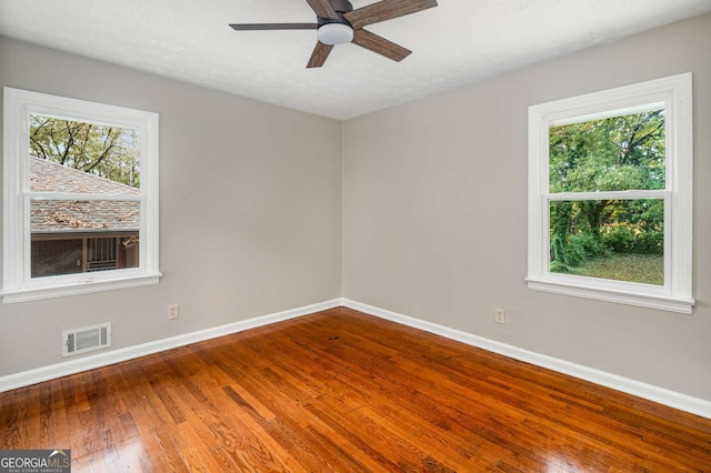 unfurnished room with hardwood / wood-style flooring, ceiling fan, a textured ceiling, and a wealth of natural light