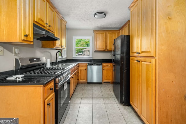 kitchen with light tile patterned flooring, appliances with stainless steel finishes, a textured ceiling, and sink