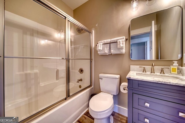 full bathroom featuring hardwood / wood-style floors, vanity, toilet, and enclosed tub / shower combo