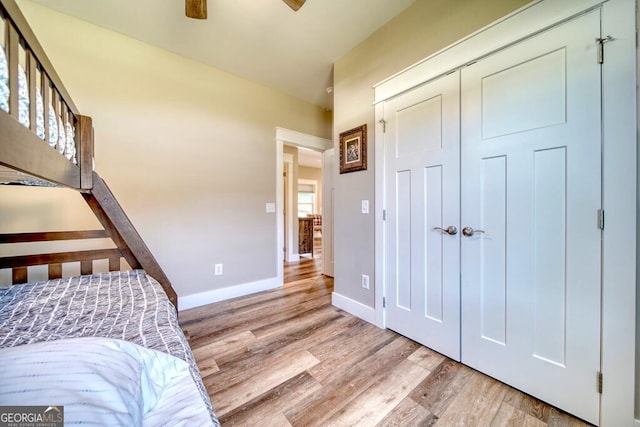 bedroom featuring ceiling fan, light wood-type flooring, and a closet