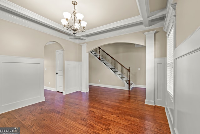 interior space featuring dark hardwood / wood-style flooring, ornamental molding, coffered ceiling, a notable chandelier, and beamed ceiling