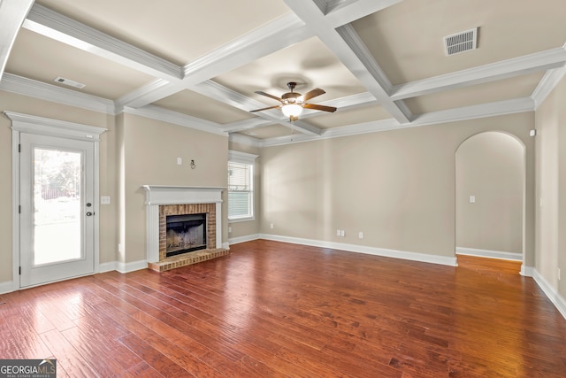 unfurnished living room featuring a brick fireplace, ceiling fan, a healthy amount of sunlight, and wood-type flooring