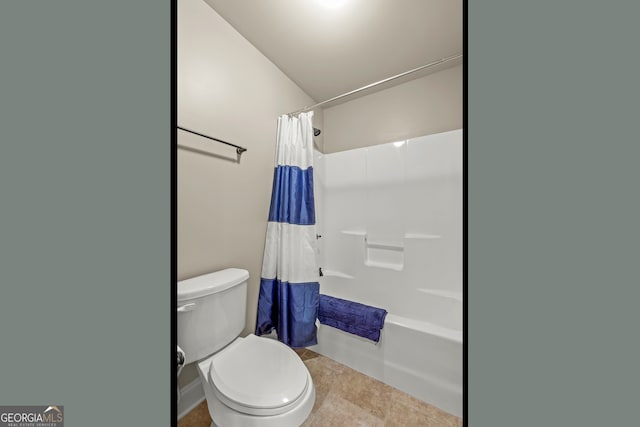 bathroom with shower / bath combo with shower curtain, tile patterned flooring, vaulted ceiling, and toilet