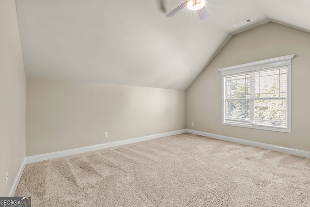 additional living space featuring light colored carpet, vaulted ceiling, and ceiling fan