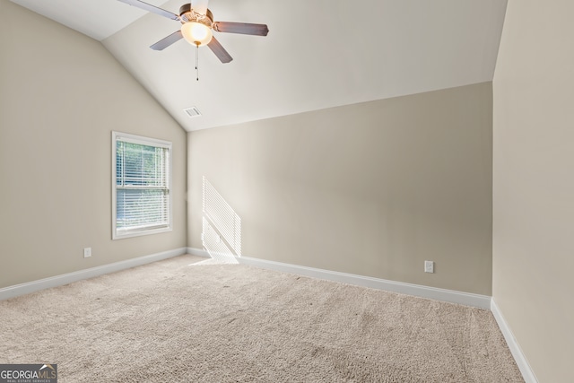 carpeted spare room featuring ceiling fan and vaulted ceiling