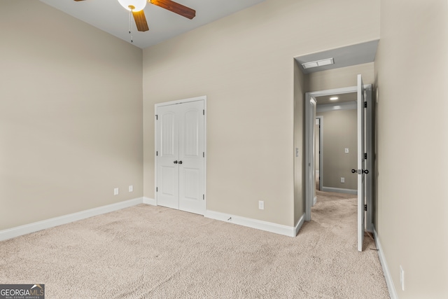 unfurnished bedroom featuring light carpet and ceiling fan