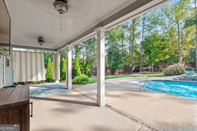 view of swimming pool featuring ceiling fan and a patio