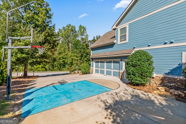 view of pool with basketball hoop