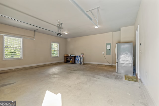 garage with electric panel, a garage door opener, and fridge