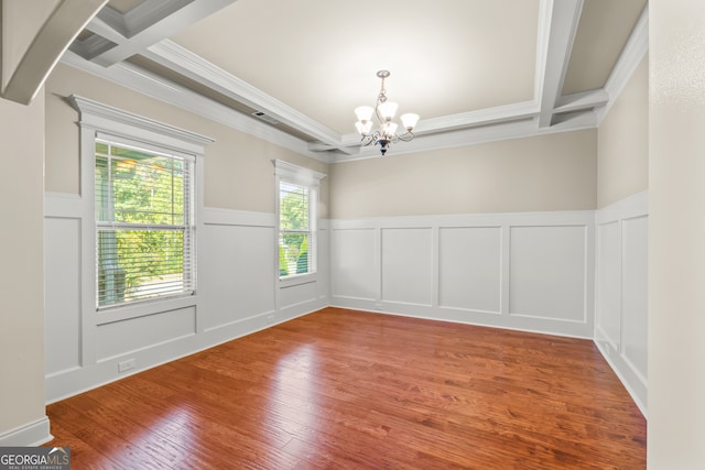 unfurnished room featuring ornamental molding, hardwood / wood-style flooring, a notable chandelier, and beam ceiling