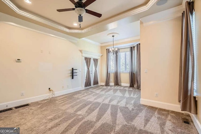 unfurnished room with a raised ceiling, crown molding, light carpet, and ceiling fan with notable chandelier