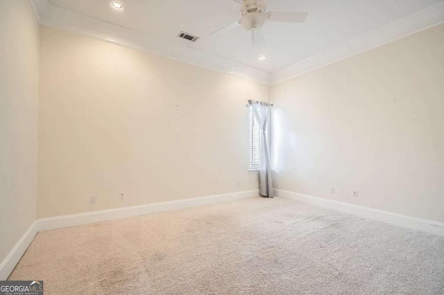 carpeted empty room with ceiling fan and crown molding