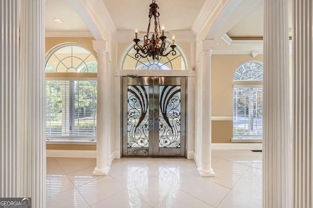 tiled foyer featuring decorative columns, french doors, a notable chandelier, and ornamental molding