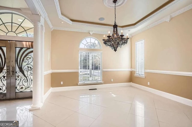 foyer featuring ornate columns, plenty of natural light, and ornamental molding