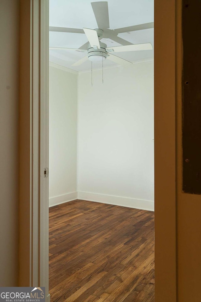 empty room featuring ceiling fan, dark hardwood / wood-style flooring, and crown molding