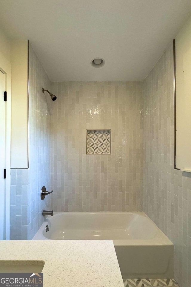 bathroom with vanity and tiled shower / bath