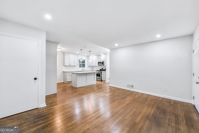 unfurnished living room with dark wood-type flooring and sink