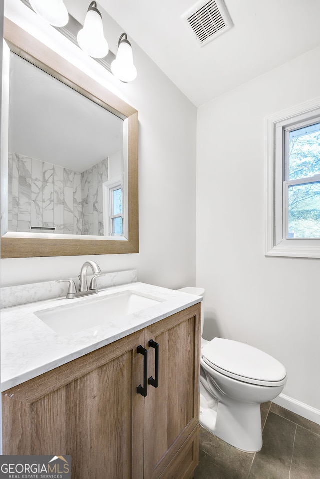 bathroom with tile patterned flooring, vanity, and toilet