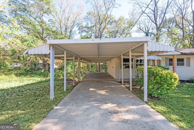 view of vehicle parking featuring a yard and a carport