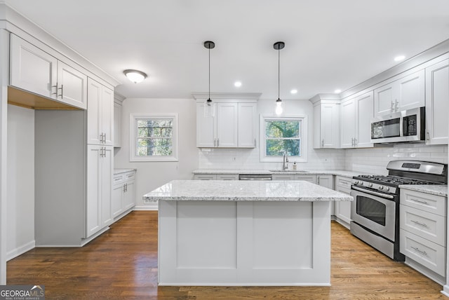 kitchen with sink, white cabinets, hardwood / wood-style floors, and appliances with stainless steel finishes