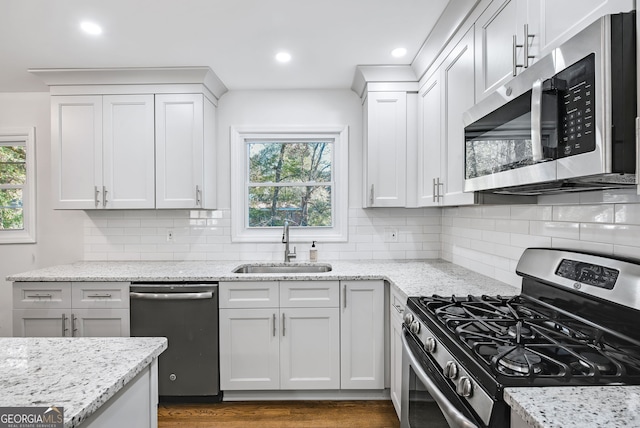 kitchen with a healthy amount of sunlight, sink, stainless steel appliances, and tasteful backsplash