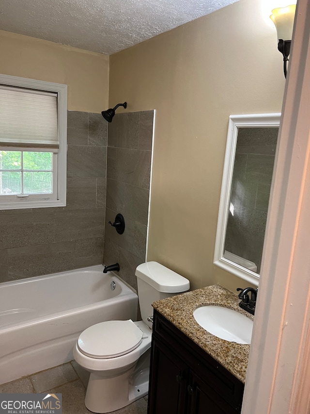 full bathroom featuring vanity, tiled shower / bath, tile patterned flooring, toilet, and a textured ceiling