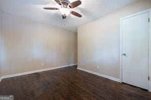 empty room with dark hardwood / wood-style floors and ceiling fan