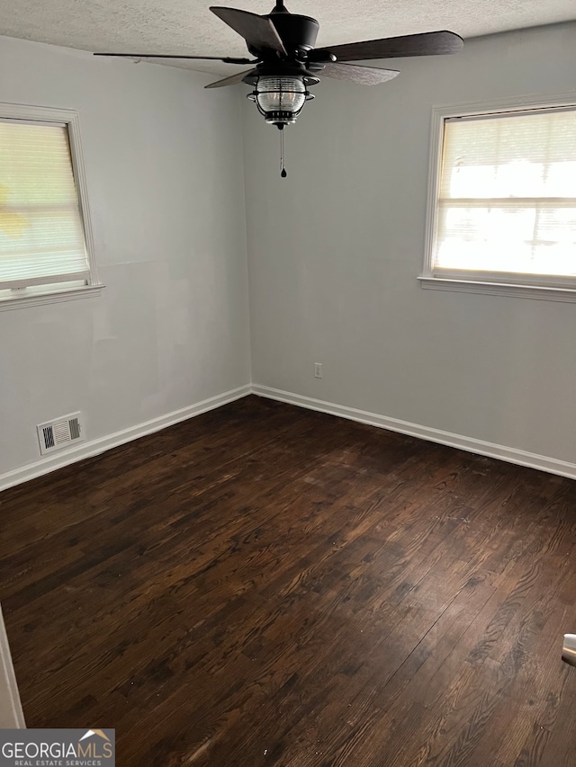 unfurnished room with ceiling fan, dark hardwood / wood-style floors, and a textured ceiling